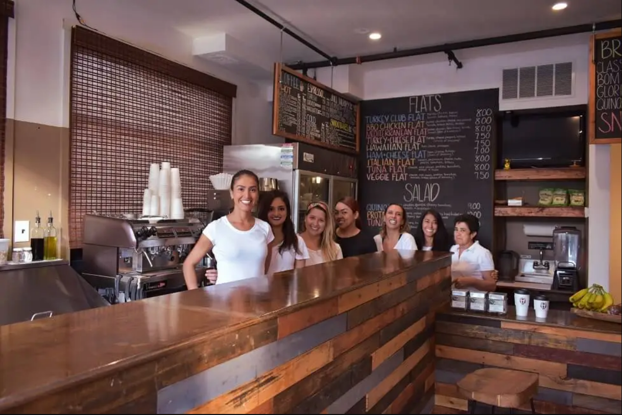 Toasted Flats employees smile for a picture behind the counter of their restaurant