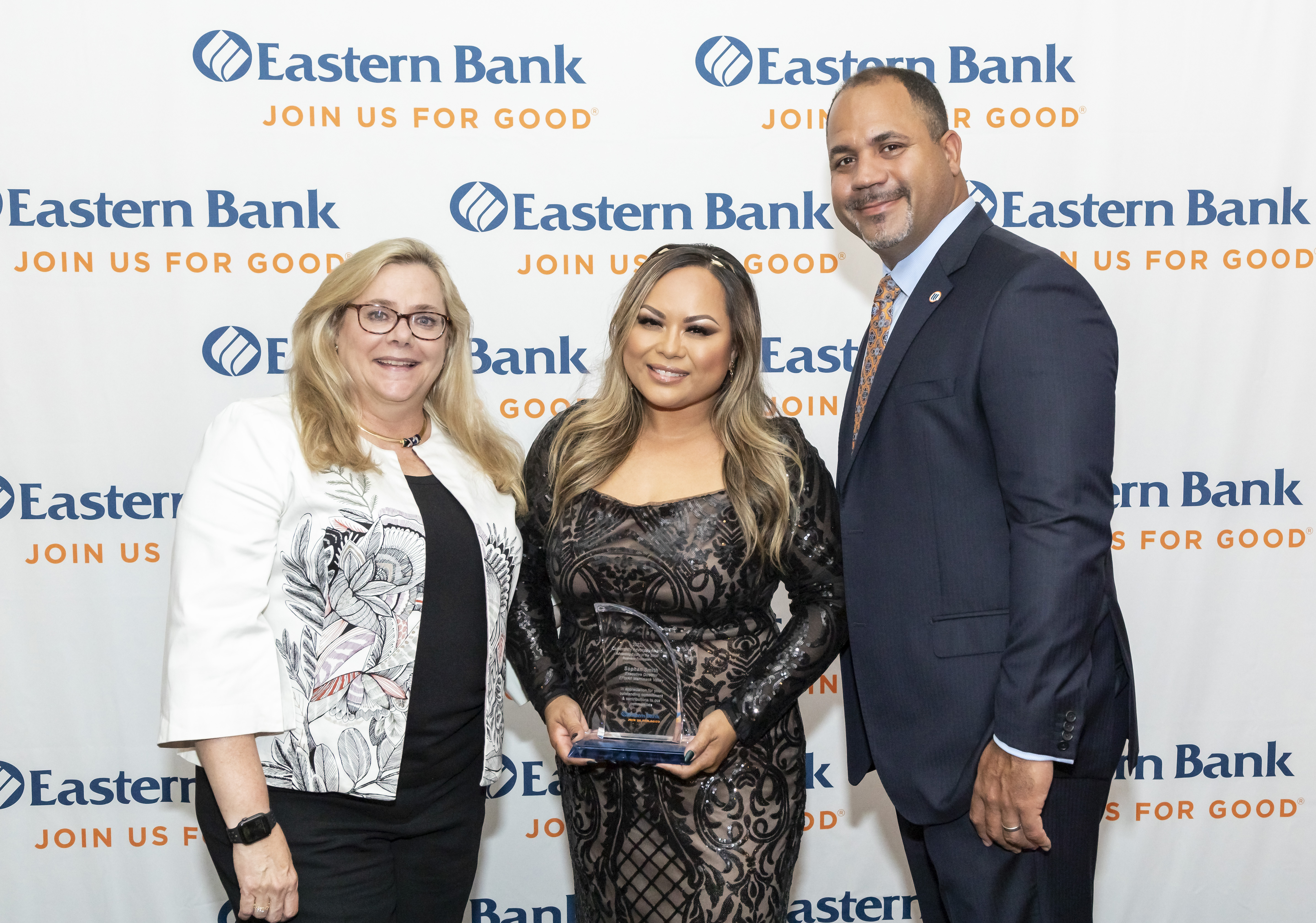 Sophan Sok holds her award and stands with Cynthia Ciman and Quincy Miller of Eastern Bank