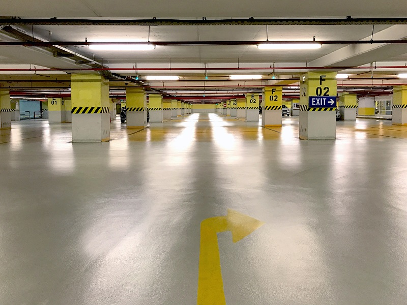 An underground parking garage with pillars painted yellow