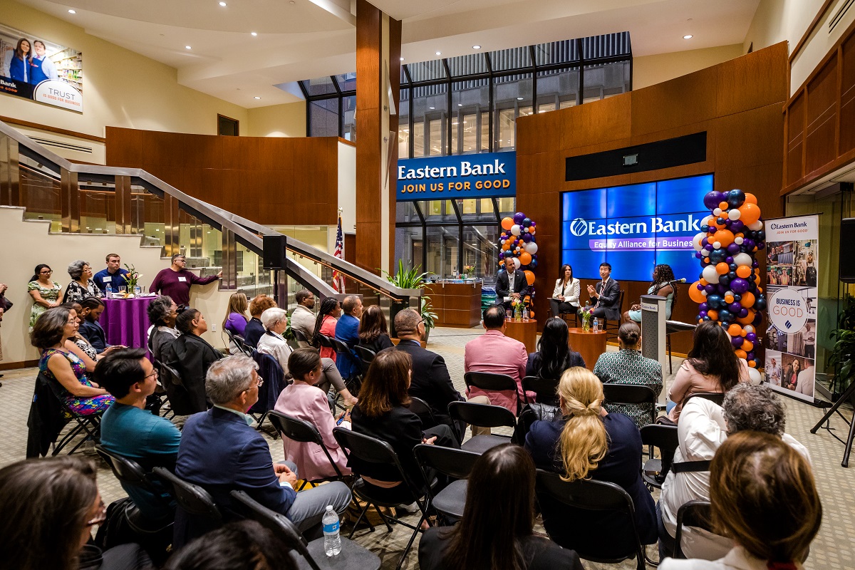 The audience sitting in front of the speakers listens intently as they speak