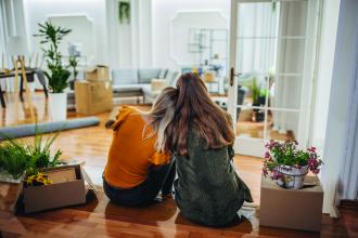 Lesbian couple sits side by side in their new home