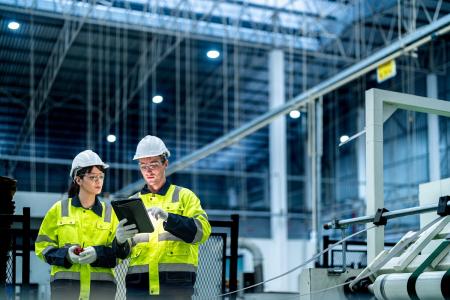 Two commercial employees use AI on a tablet to improve warehouse efficiencies