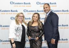 Sophan Sok holds her award and stands with Cynthia Ciman and Quincy Miller of Eastern Bank