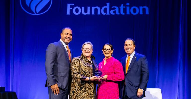Vanessa stands with Eastern Bank to receive her award