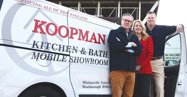 The three owners of Koopman Lumber stand in front of one their mobile showroom vans and smile at the camera
